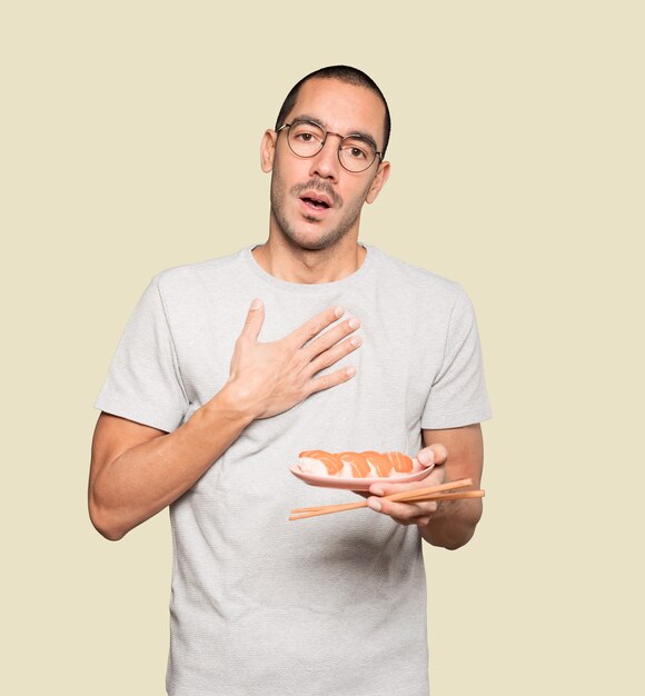 Joven con palillos para comer sushi