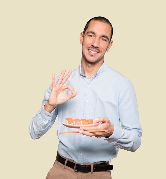 Joven con palillos para comer sushi