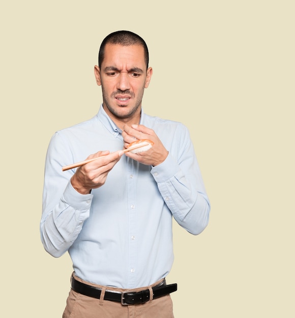 Joven con palillos para comer sushi