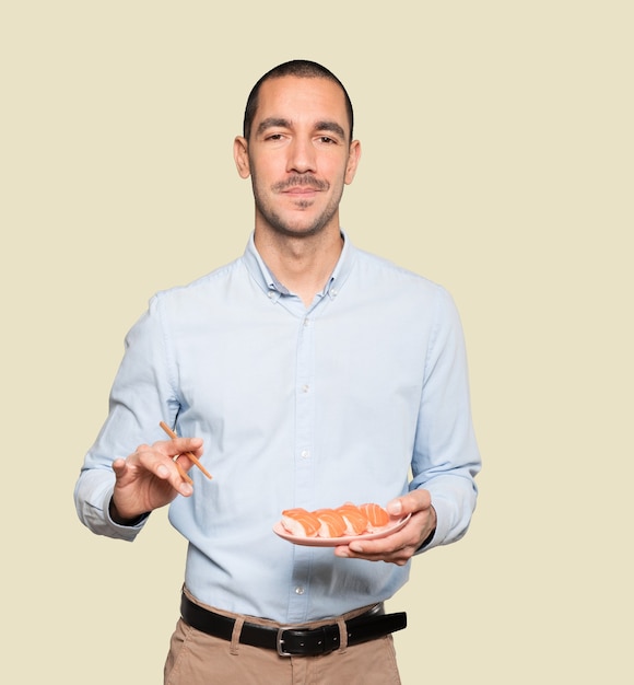 Joven con palillos para comer sushi