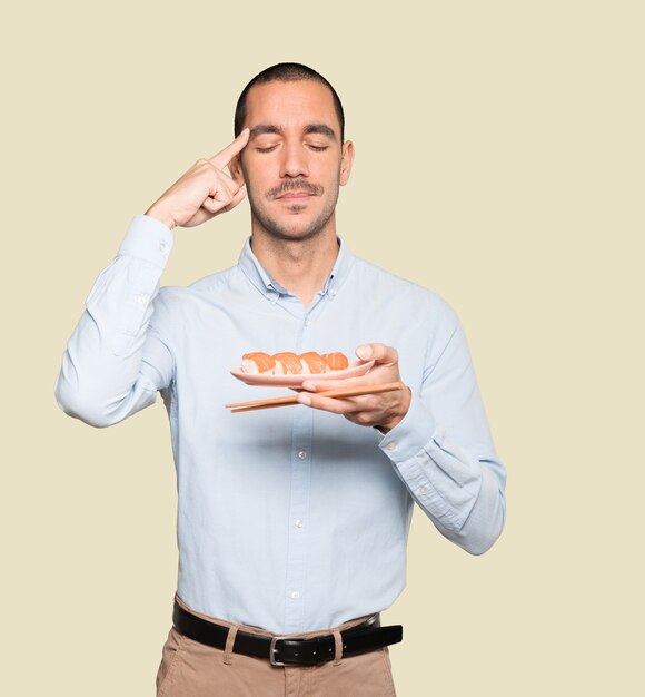 Joven con palillos para comer sushi