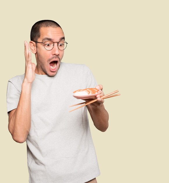 Joven con palillos para comer sushi