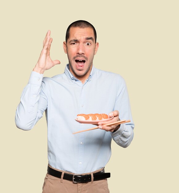 Joven con palillos para comer sushi