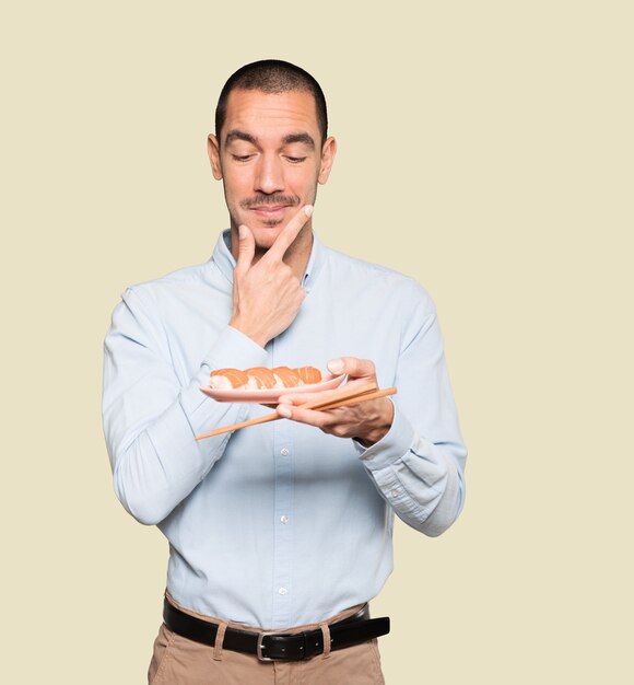 Joven con palillos para comer sushi