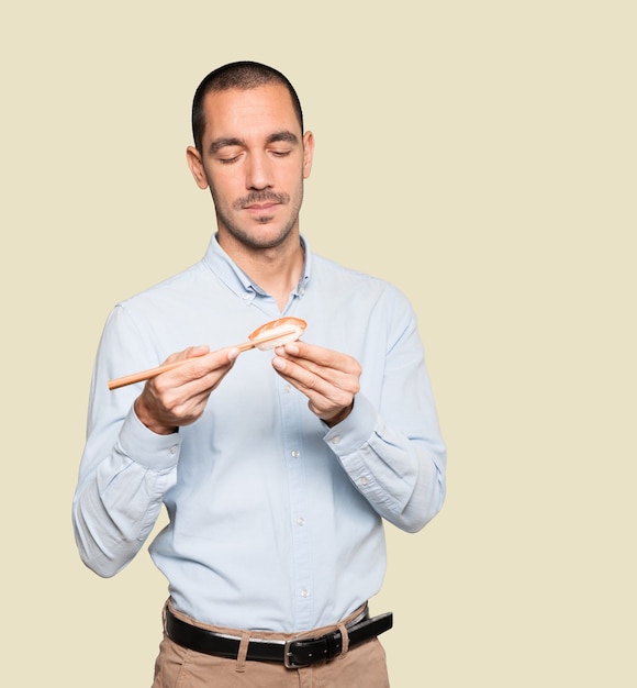 Joven con palillos para comer sushi