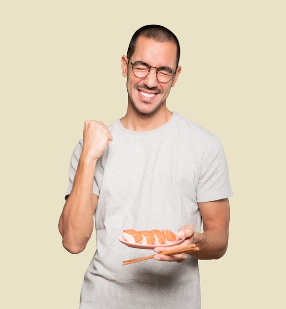 Joven con palillos para comer sushi