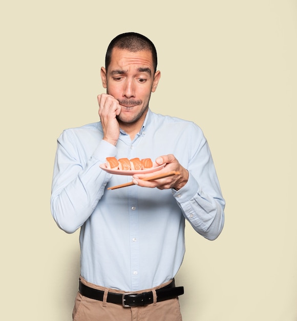 Joven con palillos para comer sushi