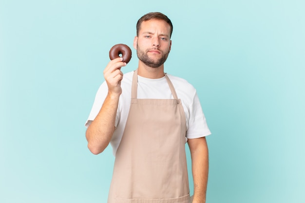 Joven panadero guapo con una rosquilla