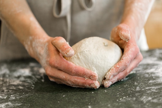 Joven panadero preparando pan de masa madre artesanal.