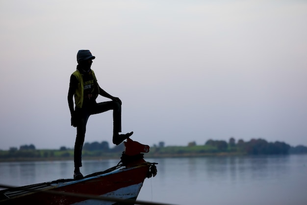 Joven parado en bote y disfruta viajando