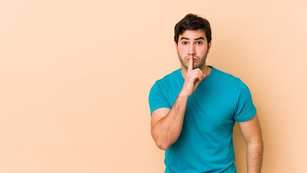 Joven en pared beige guardando un secreto