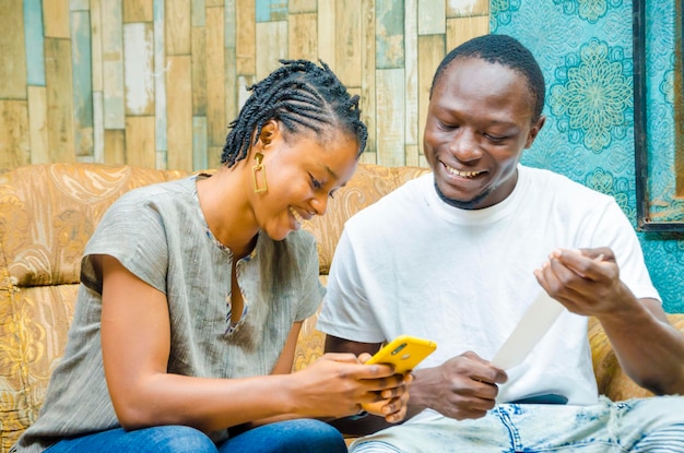 joven pareja africana pagando facturas en línea con un smartphone pagando facturas en línea