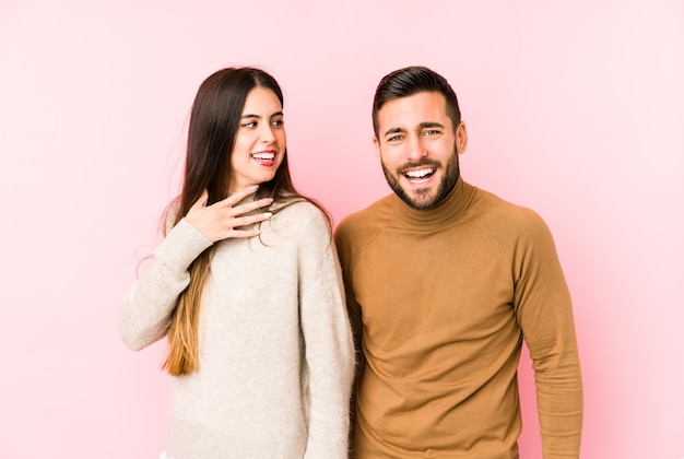 Foto joven pareja aislada ríe a carcajadas manteniendo la mano en el pecho