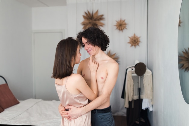 Foto joven pareja amorosa abrazándose, intimidad de hombre y mujer, retrato interior de estilo de vida