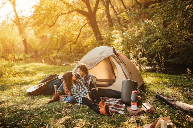 Foto joven pareja amorosa en acampar en el bosque