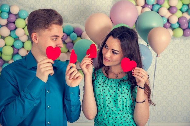 Foto joven, pareja amorosa, se besan, cubren sus labios con un caramelo en forma de corazón.