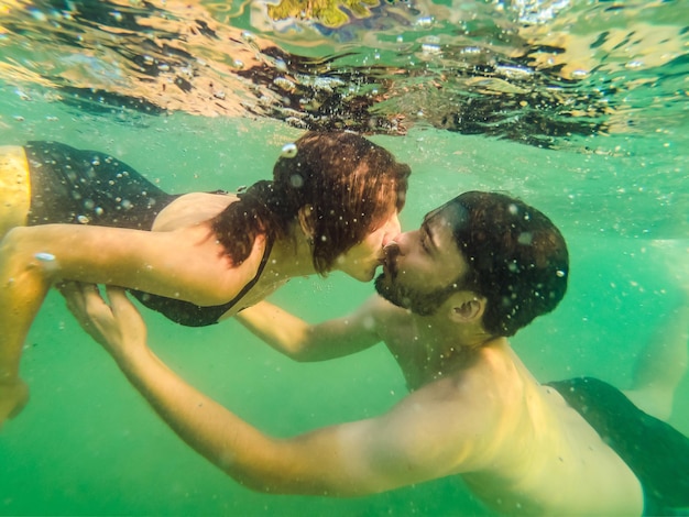 Joven pareja amorosa besos y abrazos bajo el agua