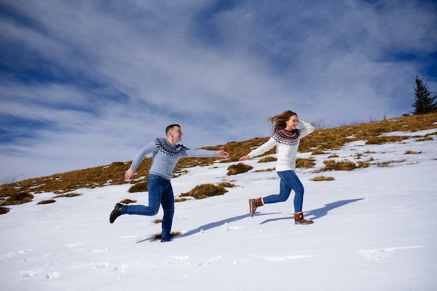 Foto joven pareja amorosa en una cita en la cima de una montaña nevada