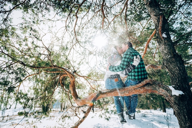 Una joven pareja amorosa descansa en las montañas en un bosque cubierto de nieve. concepto de descanso conjunto