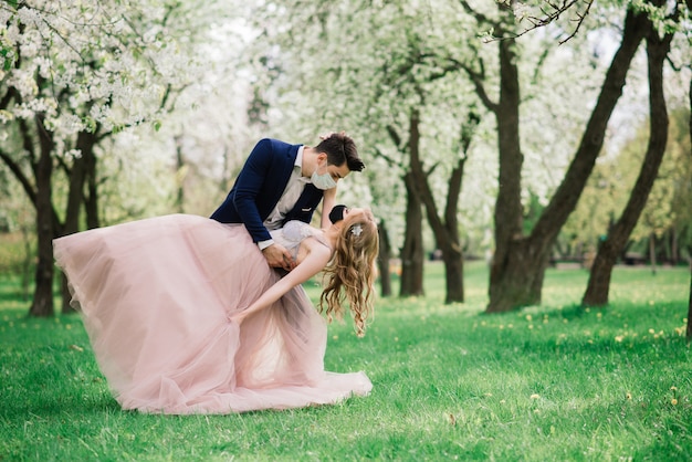 Joven pareja amorosa con mascarillas en el día de su boda