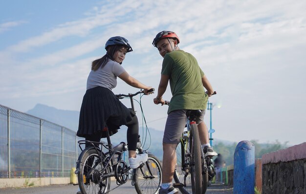 Joven pareja asiática descansando después de andar en bicicleta