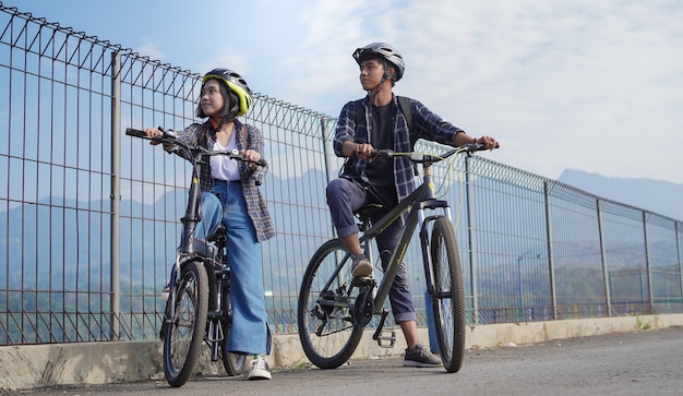 Joven pareja asiática descansar después de andar en bicicleta ir a trabajar