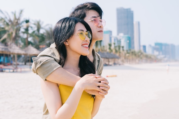 Joven pareja asiática disfrutando de las vacaciones de verano en la playa