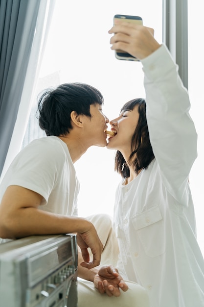 Joven pareja asiática tomando un selfie mientras juega