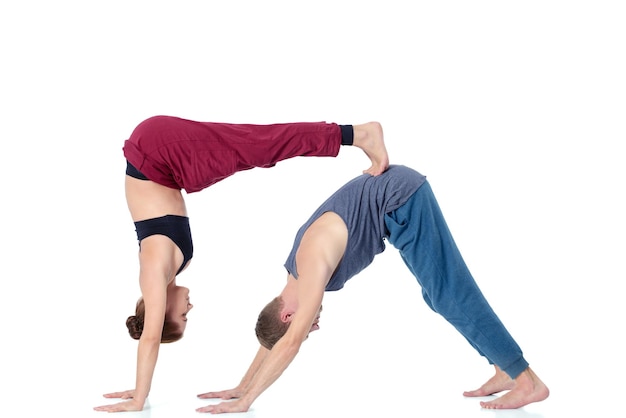 Joven pareja atlética practicando acroyoga. Equilibrio en pareja.