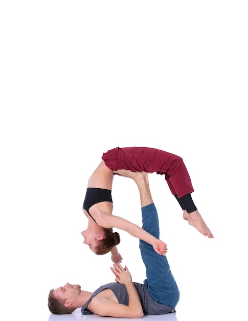 Joven pareja atlética practicando acroyoga. Equilibrio en pareja.