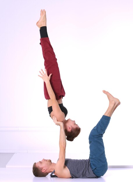 Joven pareja atlética practicando acroyoga. Equilibrio en pareja.