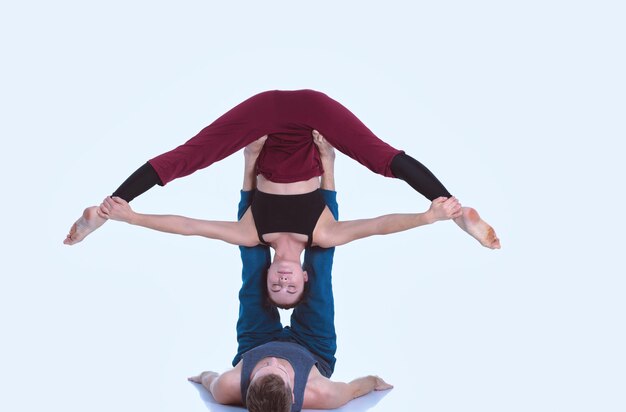 Joven pareja atlética practicando acroyoga. Equilibrio en pareja.