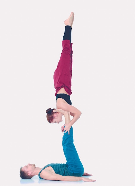 Joven pareja atlética practicando acroyoga. Equilibrio en pareja.