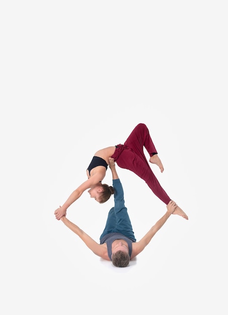 Joven pareja atlética practicando acroyoga. Equilibrio en pareja.