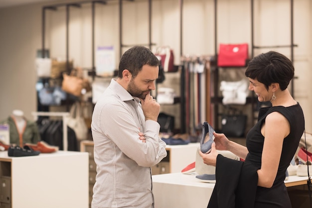 Una joven pareja atractiva cambia el look con zapatos nuevos en la zapatería