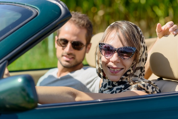 Una joven pareja en un auto convertible