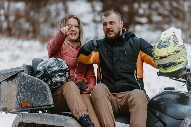 Una joven pareja aventurera abraza la alegría del amor y la emoción mientras viajan en un ATV quad a través del