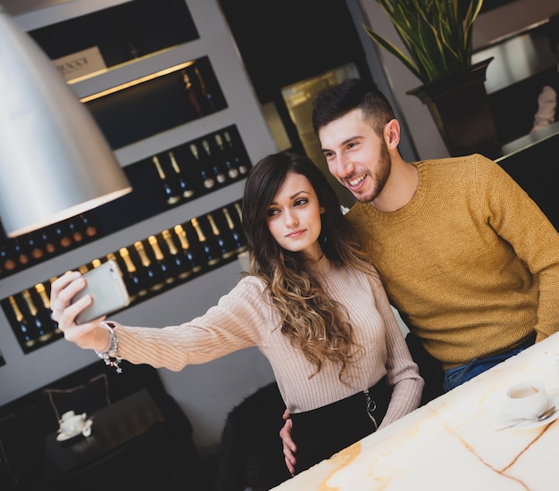 Joven pareja en el bar tomando un selfie.