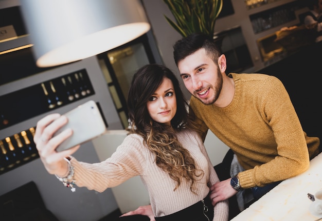 Joven pareja en el bar tomando un selfie.