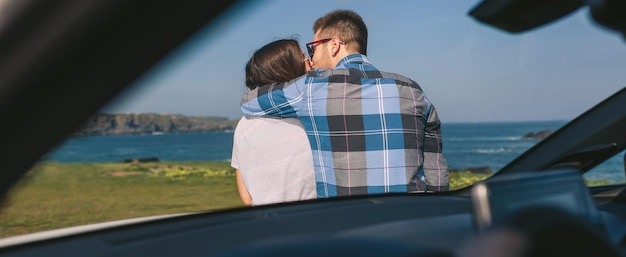 Joven pareja besándose cerca de la costa