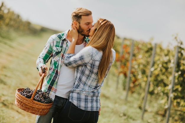 Joven pareja besándose en un viñedo