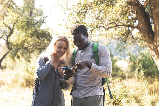 La joven pareja busca un camino en el bosque.