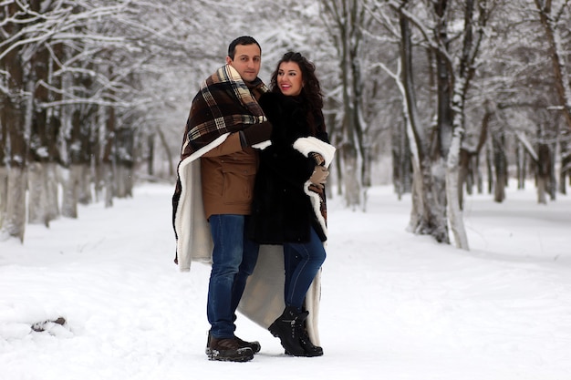 Una joven pareja camina en un parque de invierno al aire libre