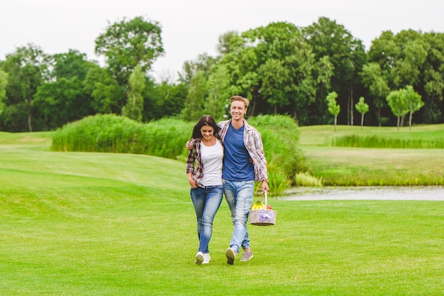 La joven pareja caminando cerca del lago.