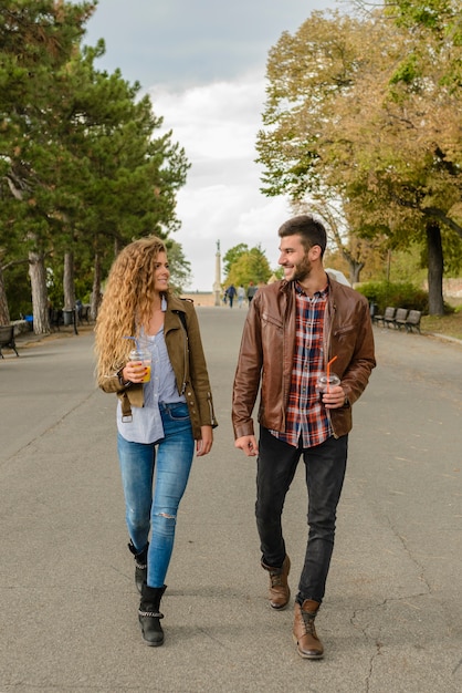 Foto joven pareja caminando en el parque de la ciudad