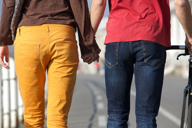 Joven pareja caminando y tomados de la mano