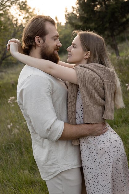 Joven pareja casada abrazándose en el parque y sonriendo el uno al otro concepto Happy seed life