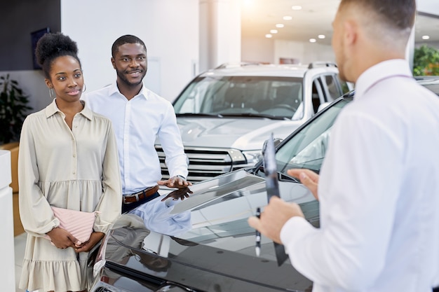 Joven pareja casada afroamericana vino a mirar el coche para una futura compra