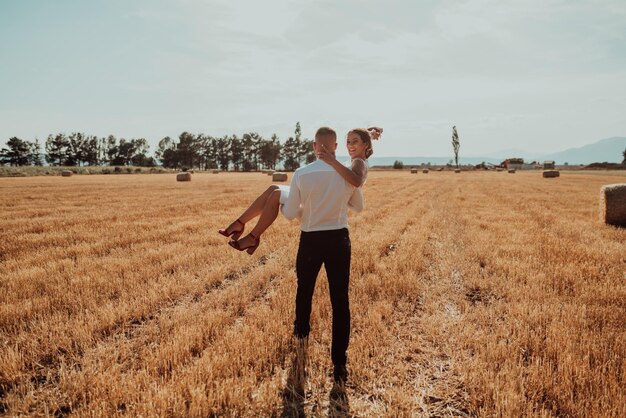 una joven pareja casada en un gran campo disfruta de la puesta de sol. Enfoque selectivo. foto de alta calidad