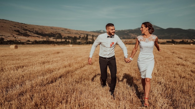 una joven pareja casada en un gran campo disfruta de la puesta de sol. Enfoque selectivo. foto de alta calidad